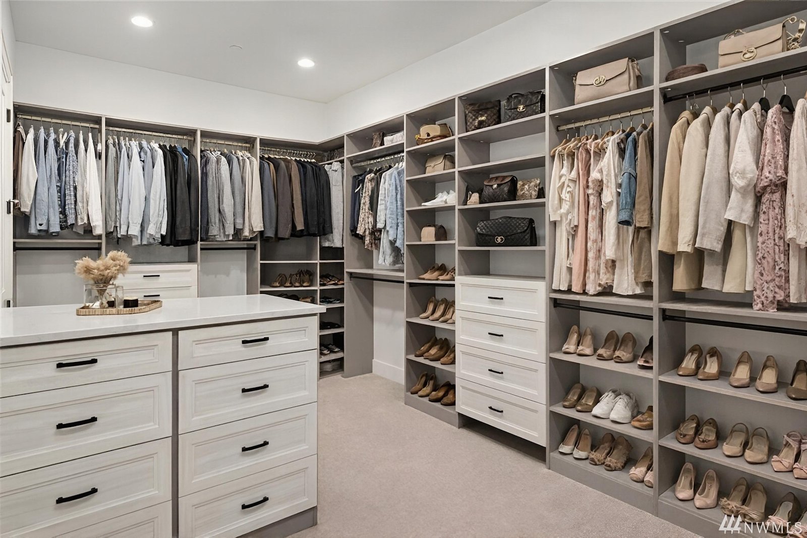 Expansive custom walk-in closet with center island and organized shelving by Create More Space
