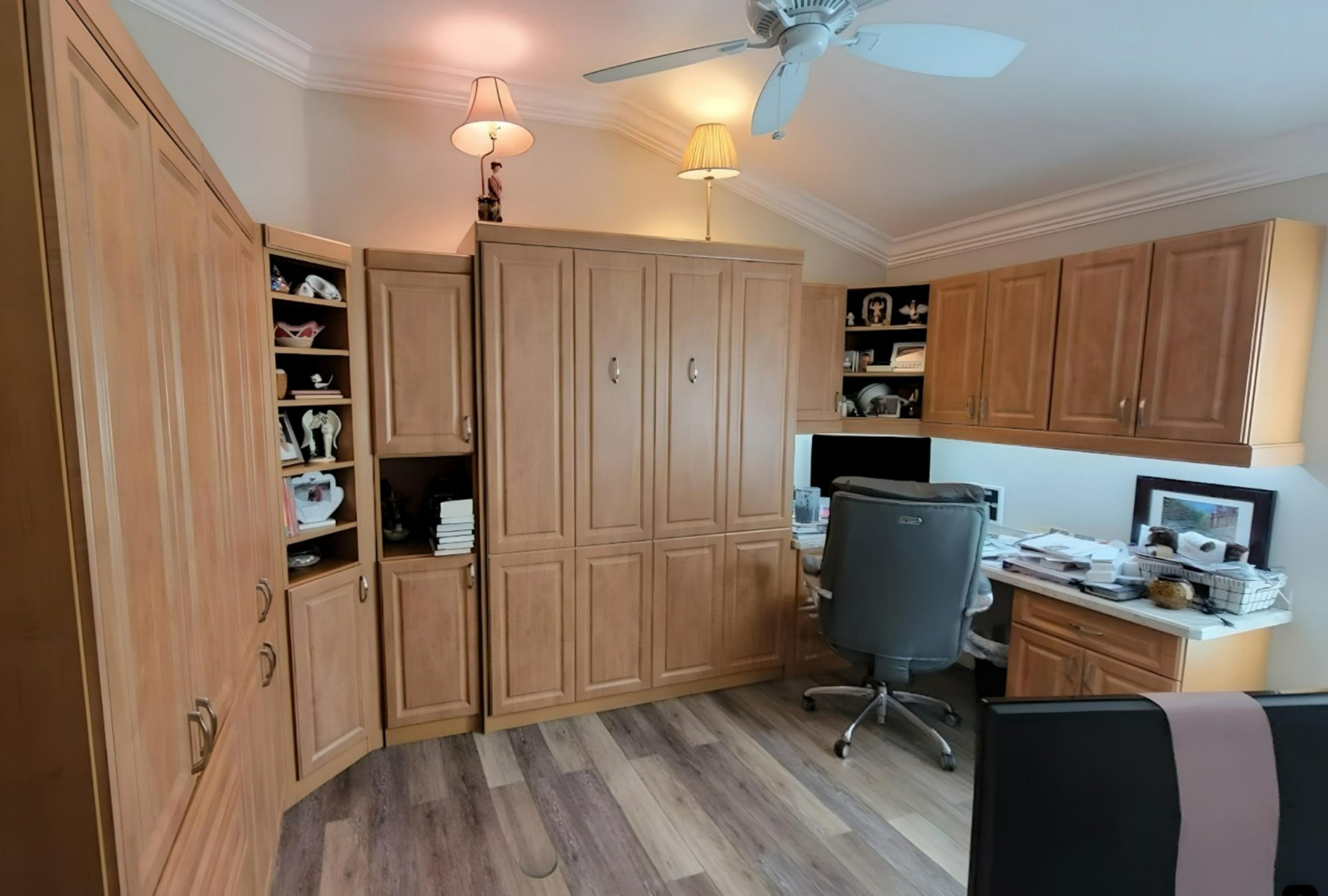 Wood home office with desk and upper cabinetry by Create More Space