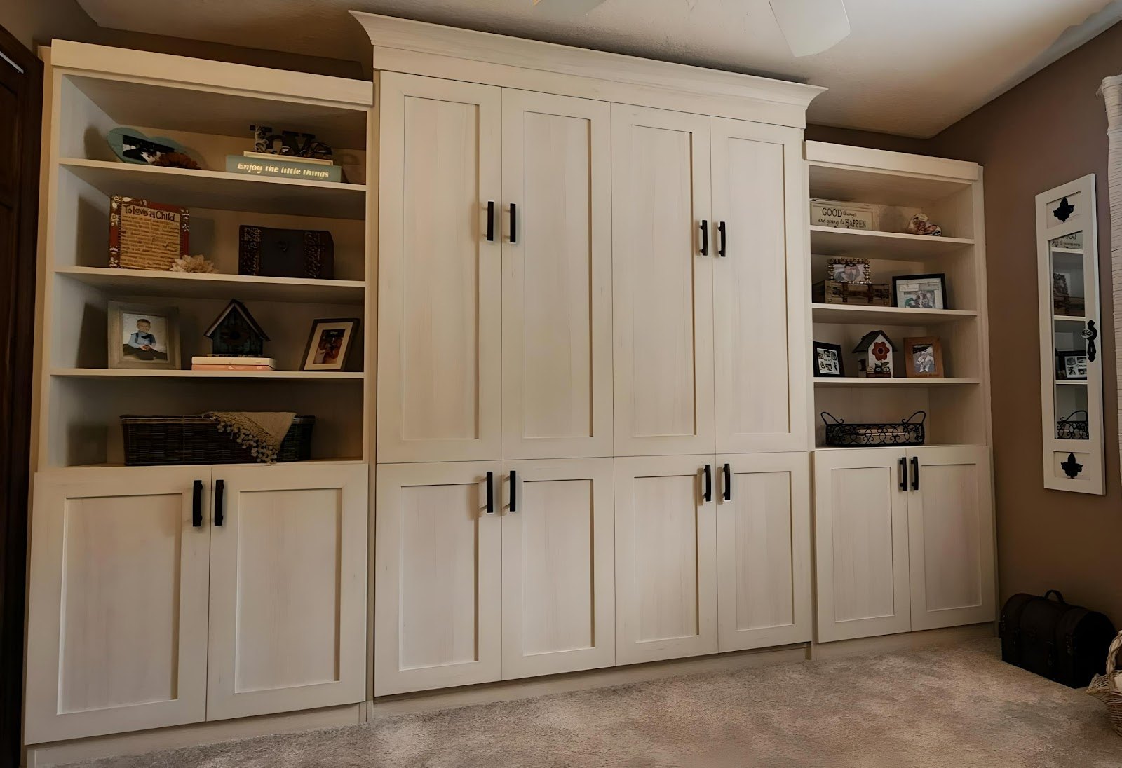 Large cream wall bed unit with cabinets and open display shelving
