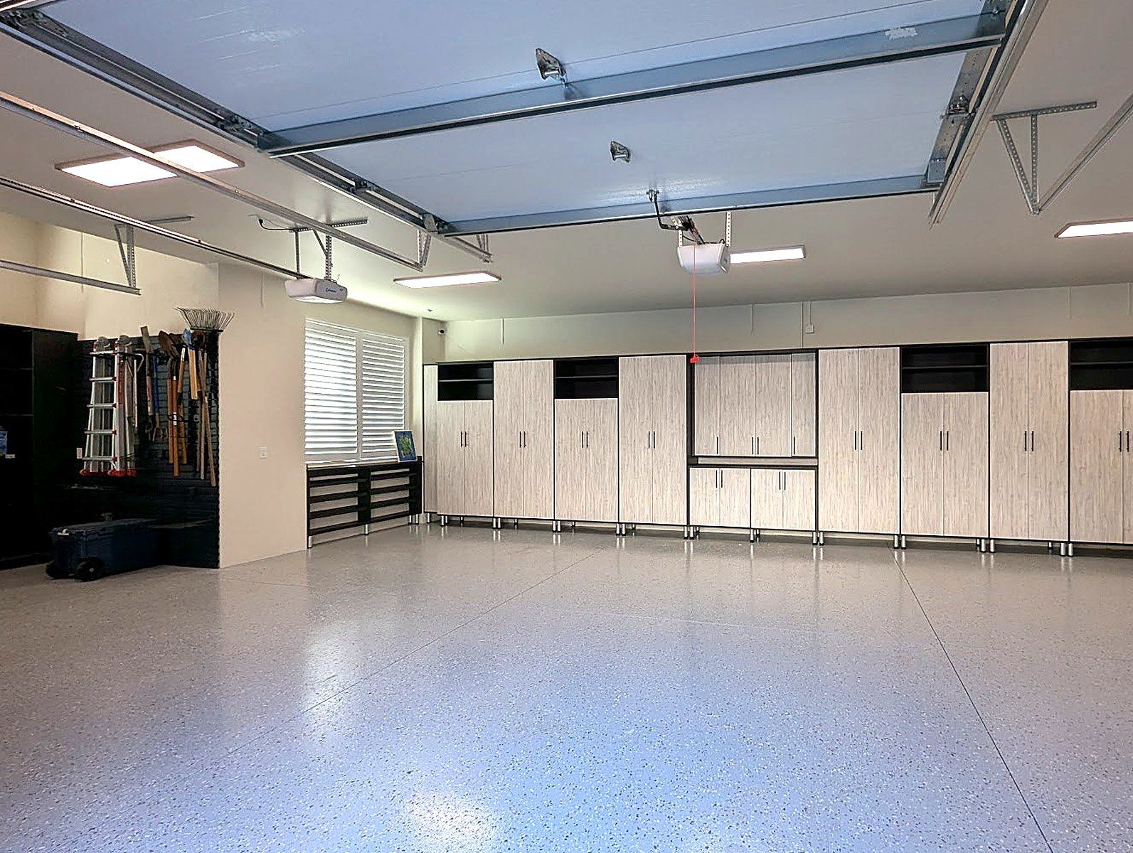 Organized custom garage with slat wall, workbench and cabinetry