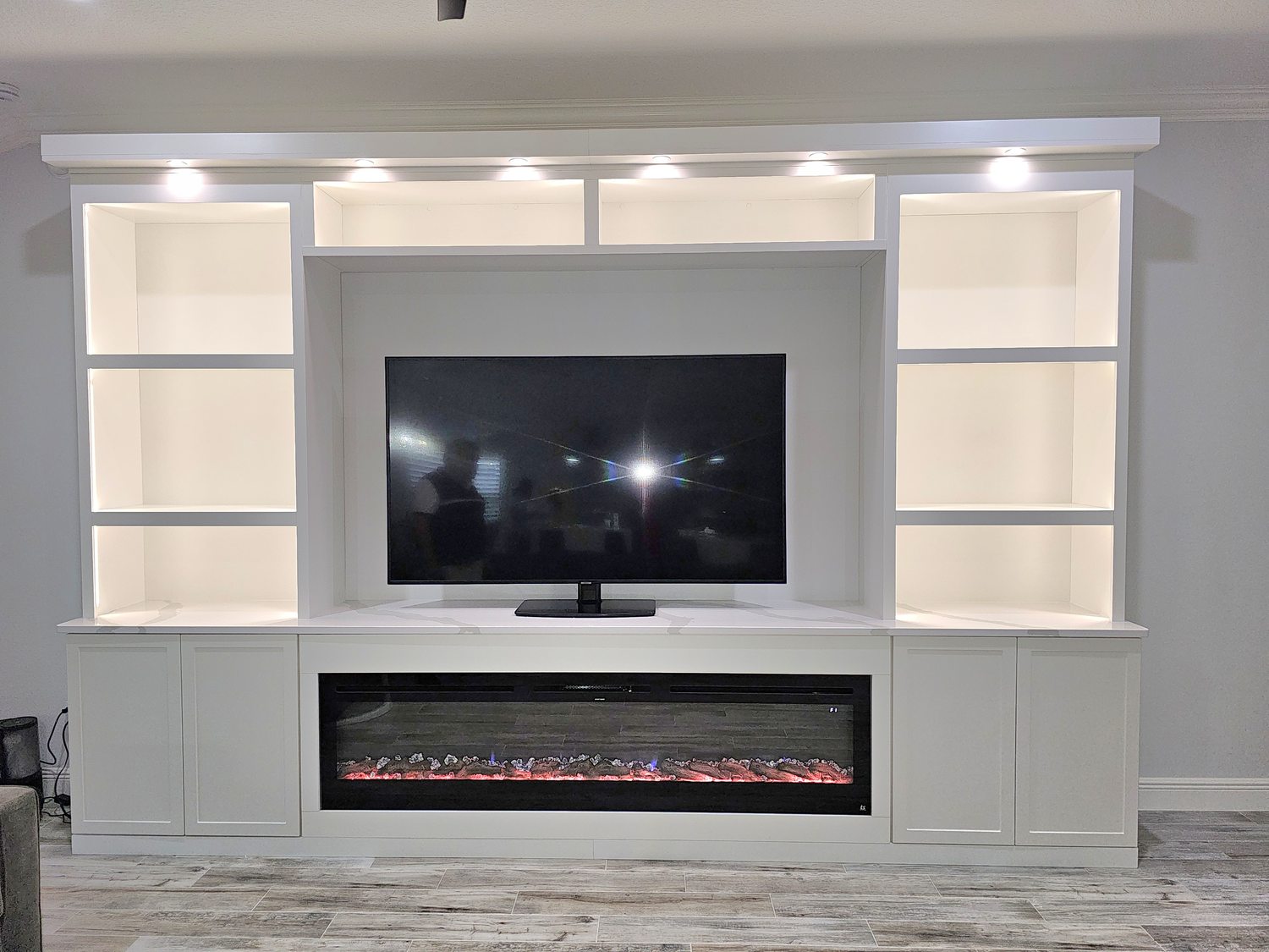Media wall with linear fireplace and lit display niches