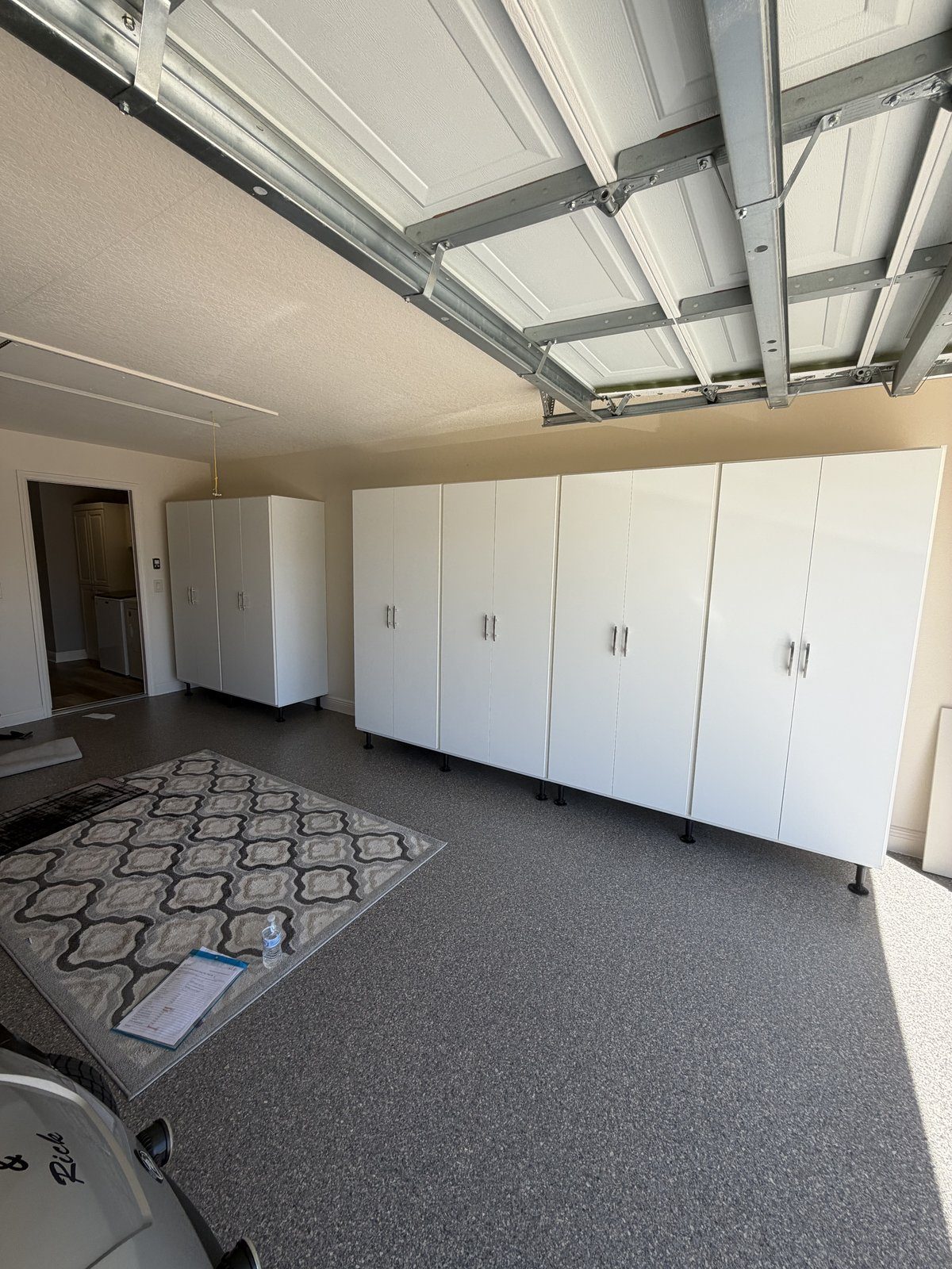 Garage with full-wall cabinetry, workbench and slat wall storage